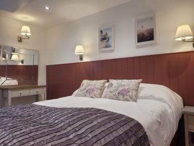 comfy bed in a farm-cottage-style bedroom
